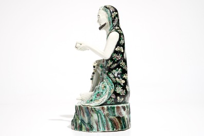 Een Chinese verte biscuit figuur van een luohan met schriftrol, Kangxi