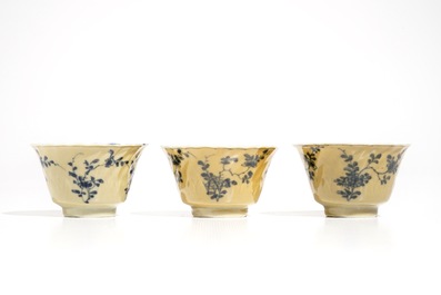 Three Chinese blue and white and caf&eacute; au lait-glazed cups and saucers, Kangxi