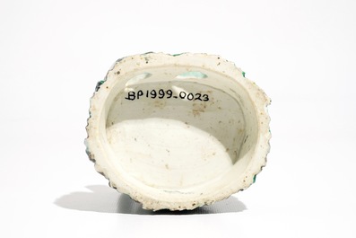 Een Chinese verte biscuit figuur van een luohan met schriftrol, Kangxi