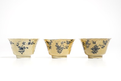 Three Chinese blue and white and caf&eacute; au lait-glazed cups and saucers, Kangxi