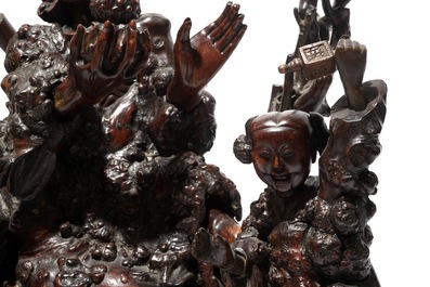 A large Chinese carved root wood group with a Luohan, 19th C.