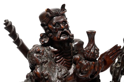 A large Chinese carved root wood group with a Luohan, 19th C.