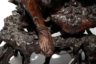 A large Chinese carved root wood group with a Luohan, 19th C.