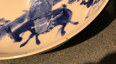Une paire d'assiettes en porcelaine de Chine bleu et blanc aux d&eacute;cors d'un sage sur un &acirc;ne, marque et &eacute;poque de Kangxi