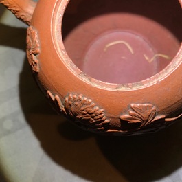 Een Chinese Yixing steengoed theepot met reli&euml;fdecor, Kangxi