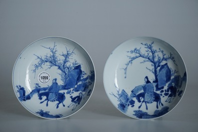Une paire d'assiettes en porcelaine de Chine bleu et blanc aux d&eacute;cors d'un sage sur un &acirc;ne, marque et &eacute;poque de Kangxi
