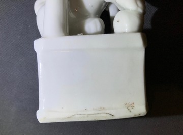 A Chinese Dehua blanc de Chine temple lion, a vase and a blue and white tea caddy, Kangxi and later