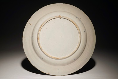 Un plat en fa&iuml;ence de Delft bleu et blanc figurant "Le jeune p&ecirc;cheur" d'apr&egrave;s Bloemaert, 18&egrave;me