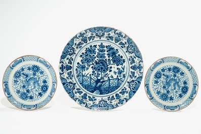 Five Dutch Delft blue and white plates with dragons, tea trees and a peacock's tail, 17/18th C.