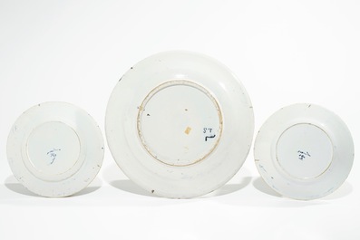 Five Dutch Delft blue and white plates with dragons, tea trees and a peacock's tail, 17/18th C.