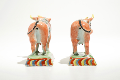A pair of polychrome Dutch Delft petit feu cows on bases, 18th C.