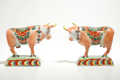 A pair of polychrome Dutch Delft petit feu cows on bases, 18th C.