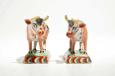 A pair of polychrome Dutch Delft petit feu cows on bases, 18th C.