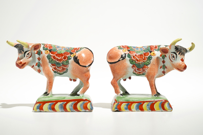 A pair of polychrome Dutch Delft petit feu cows on bases, 18th C.