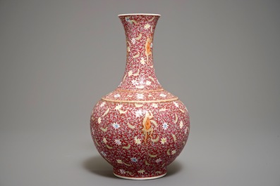 A Chinese ruby-ground famille rose bottle vase with dancing boys, Qianlong mark, 19/20th C.