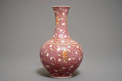 A Chinese ruby-ground famille rose bottle vase with dancing boys, Qianlong mark, 19/20th C.