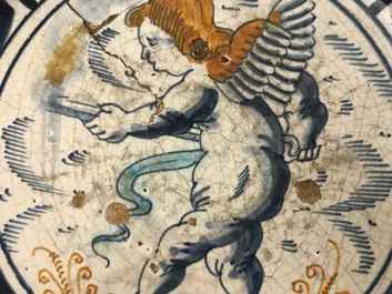A rare Dutch Delft or Haarlem maiolica dish with a putto, 1st half 17th C.