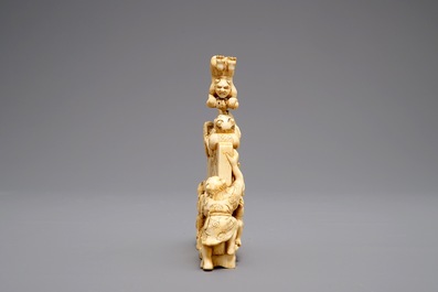 A Japanese carved ivory okimono with oni around a screen, signed, Meiji, 19th C.