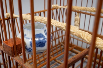 A Chinese wooden bird cage with ivory and porcelain ornaments, 19/20th C.