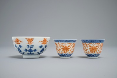 A pair of Chinese iron red and blue cups and a bowl, Qianlong and Guangxu marks, 19/20th C.