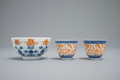 A pair of Chinese iron red and blue cups and a bowl, Qianlong and Guangxu marks, 19/20th C.