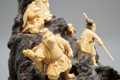 A Japanese carved ivory group on rootwood base, prob. Tokyo school, Meiji, 19th C.