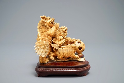 A Chinese carved ivory group of Buddhist lions playing with a ball, 19/20th C.