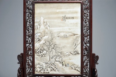 Un &eacute;cran de table en bois sculpt&eacute; mont&eacute; d'une plaque &agrave; d&eacute;cor d'un paysage hivernale d'apr&egrave;s He Xuren, 20&egrave;me