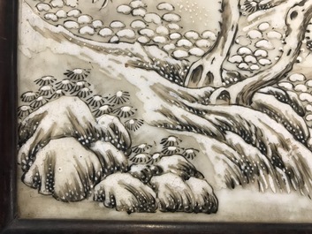 Un &eacute;cran de table en bois sculpt&eacute; mont&eacute; d'une plaque &agrave; d&eacute;cor d'un paysage hivernale d'apr&egrave;s He Xuren, 20&egrave;me