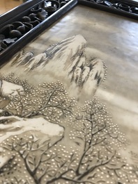 Un &eacute;cran de table en bois sculpt&eacute; mont&eacute; d'une plaque &agrave; d&eacute;cor d'un paysage hivernale d'apr&egrave;s He Xuren, 20&egrave;me