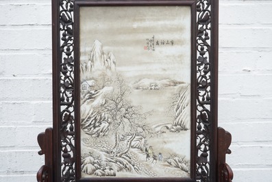 Un &eacute;cran de table en bois sculpt&eacute; mont&eacute; d'une plaque &agrave; d&eacute;cor d'un paysage hivernale d'apr&egrave;s He Xuren, 20&egrave;me