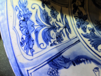 Un plat en porcelaine de Chine bleu et blanc &agrave; d&eacute;cor de figures dans un paysage, &eacute;poque Transition
