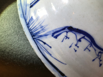 Un plat en porcelaine de Chine bleu et blanc &agrave; d&eacute;cor de figures dans un paysage, &eacute;poque Transition