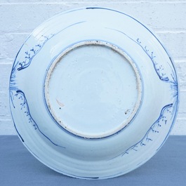 Un plat en porcelaine de Chine bleu et blanc &agrave; d&eacute;cor de figures dans un paysage, &eacute;poque Transition