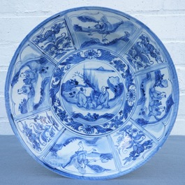 Un plat en porcelaine de Chine bleu et blanc &agrave; d&eacute;cor de figures dans un paysage, &eacute;poque Transition