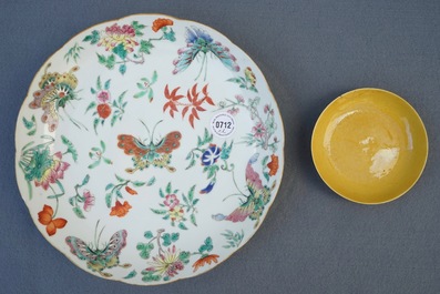 Une coupe en porcelaine de Chine jaune monochrome, marque et &eacute;poque de Tongzhi, et une assiette aux papillons, 19&egrave;me