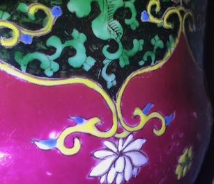 A pair of Chinese famille rose black-ground vases and covers, Yongzheng