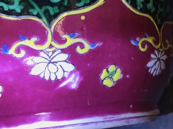 A pair of Chinese famille rose black-ground vases and covers, Yongzheng