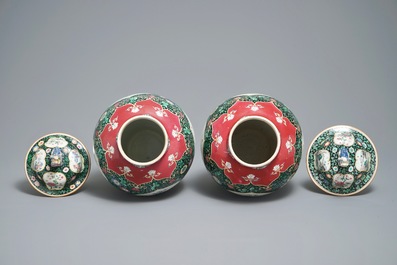 A pair of Chinese famille rose black-ground vases and covers, Yongzheng