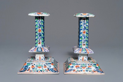 A pair of clobbered Chinese blue and white candlesticks, Kangxi