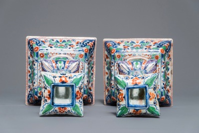 A pair of clobbered Chinese blue and white candlesticks, Kangxi