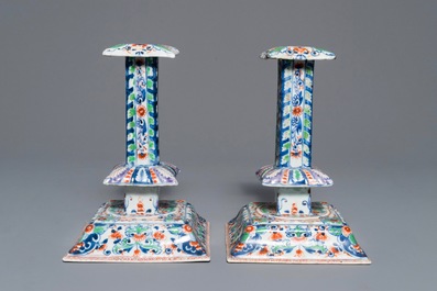 A pair of clobbered Chinese blue and white candlesticks, Kangxi
