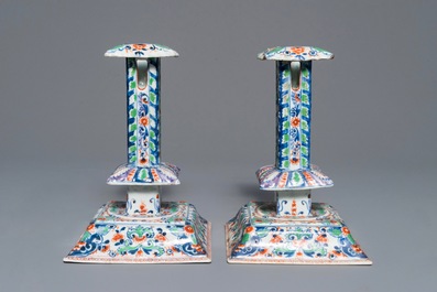 A pair of clobbered Chinese blue and white candlesticks, Kangxi