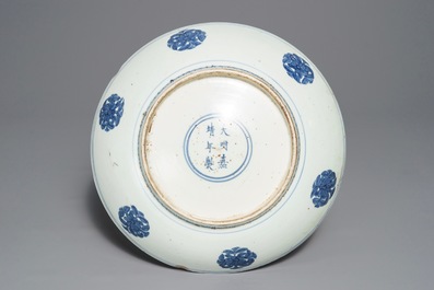 Un plat en porcelaine de Chine bleu et blanc &agrave; d&eacute;cor de grues, marque et &eacute;poque de Jiajing
