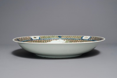 A massive Chinese famille verte dish with figures in a landscape, 19th C.
