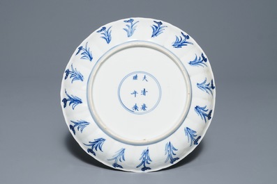 Une assiette en forme de lotus en porcelaine de Chine bleu et blanc, marque et &eacute;poque de Kangxi
