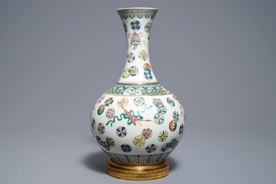 Un vase de forme bouteille en porcelaine de Chine famille rose sur socle en bronze, 19&egrave;me
