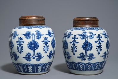 A pair of Chinese blue and white jars and wooden covers, 18/19th C.
