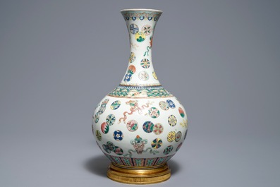 Un vase de forme bouteille en porcelaine de Chine famille rose sur socle en bronze, 19&egrave;me