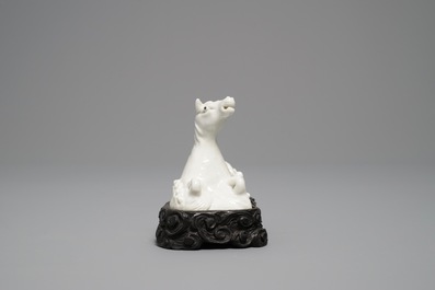 Un mod&egrave;le d'un cheval en porcelaine blanc de Chine de Dehua sur socle sculpt&eacute;, Kangxi